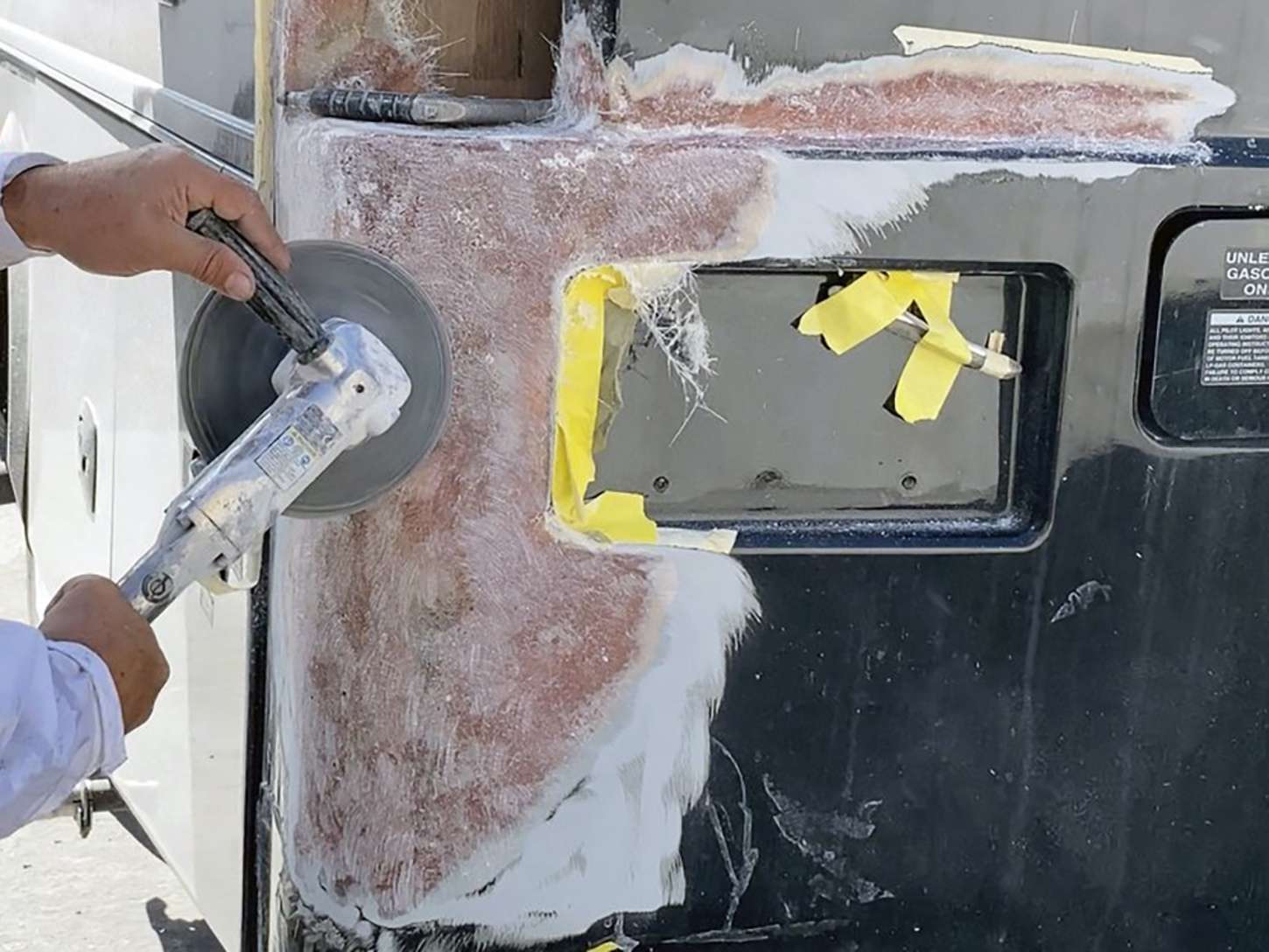 Technician laying fiberglass cloth into a repaired sidewall